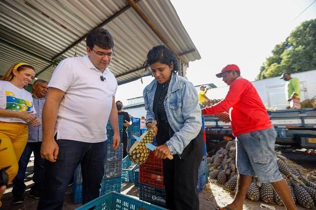 Rafael Fonteles observa agilidade da vendedora de abacaxi na Nova Ceasa